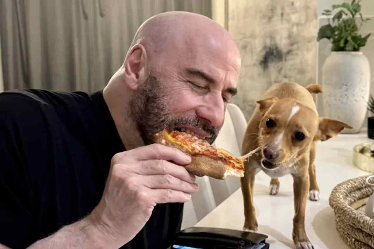Imágenes tiernas: John Travolta comparte pizza y abraza al perro de su hijo